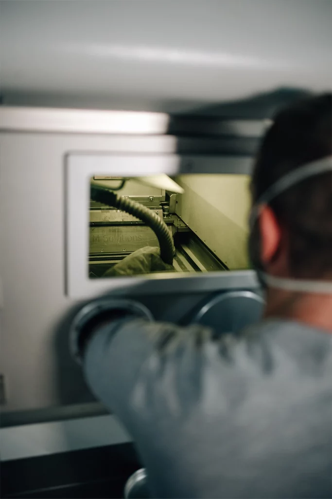 Mitarbeiter bei Parare arbeitet an einer Anlage zur additiven Fertigung und Nachbearbeitung